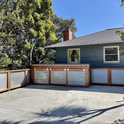 Cement parking deck with wood and metal railing and trash enclosures 