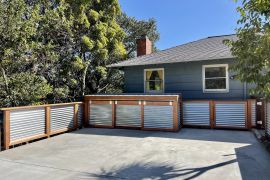 Cement parking deck with wood and metal railing and trash enclosures